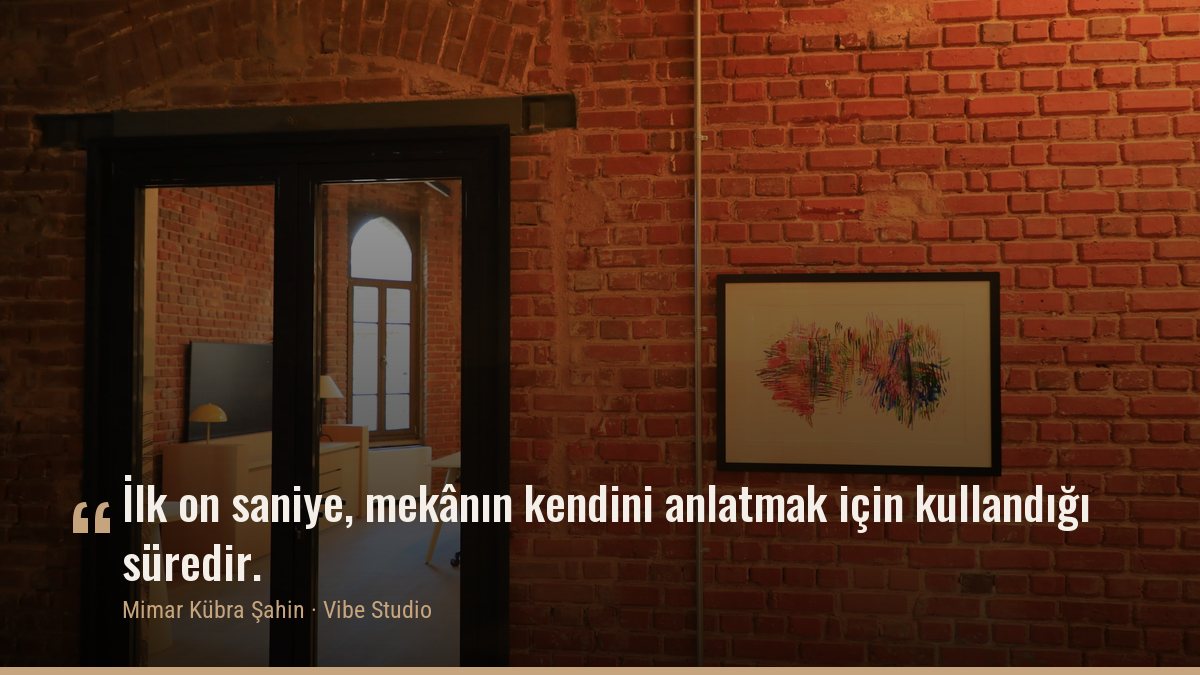 Tuğla duvarlı bir iç mekânda aydınlık bir odaya açılan kapı boşluğu; üzerinde yazıdan alınmış bir cümle — Vibe Studio